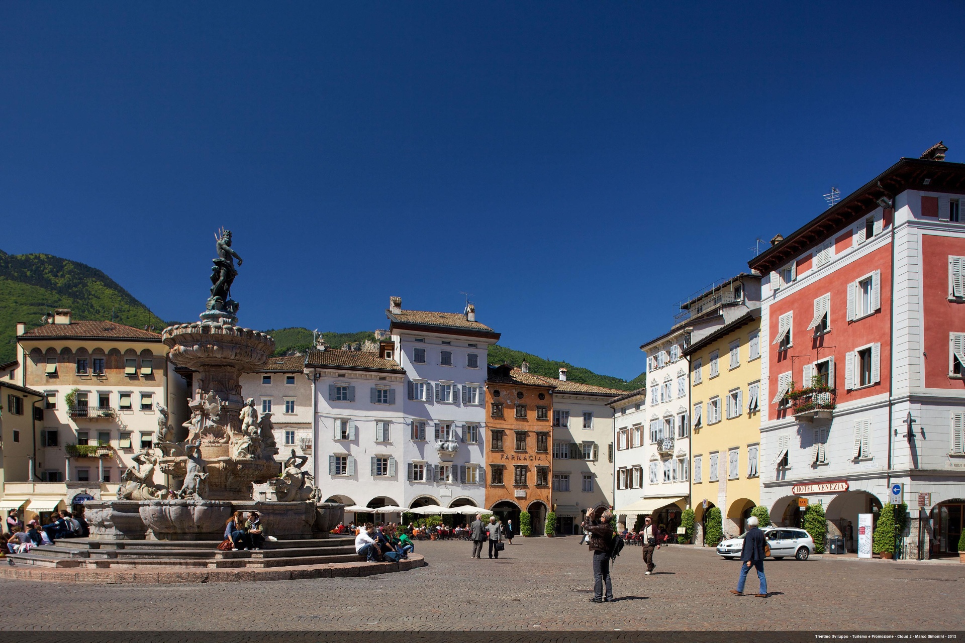 Piazza Duomo in Trento mit Neptunbrunnen, bunten Häusern und Bergen